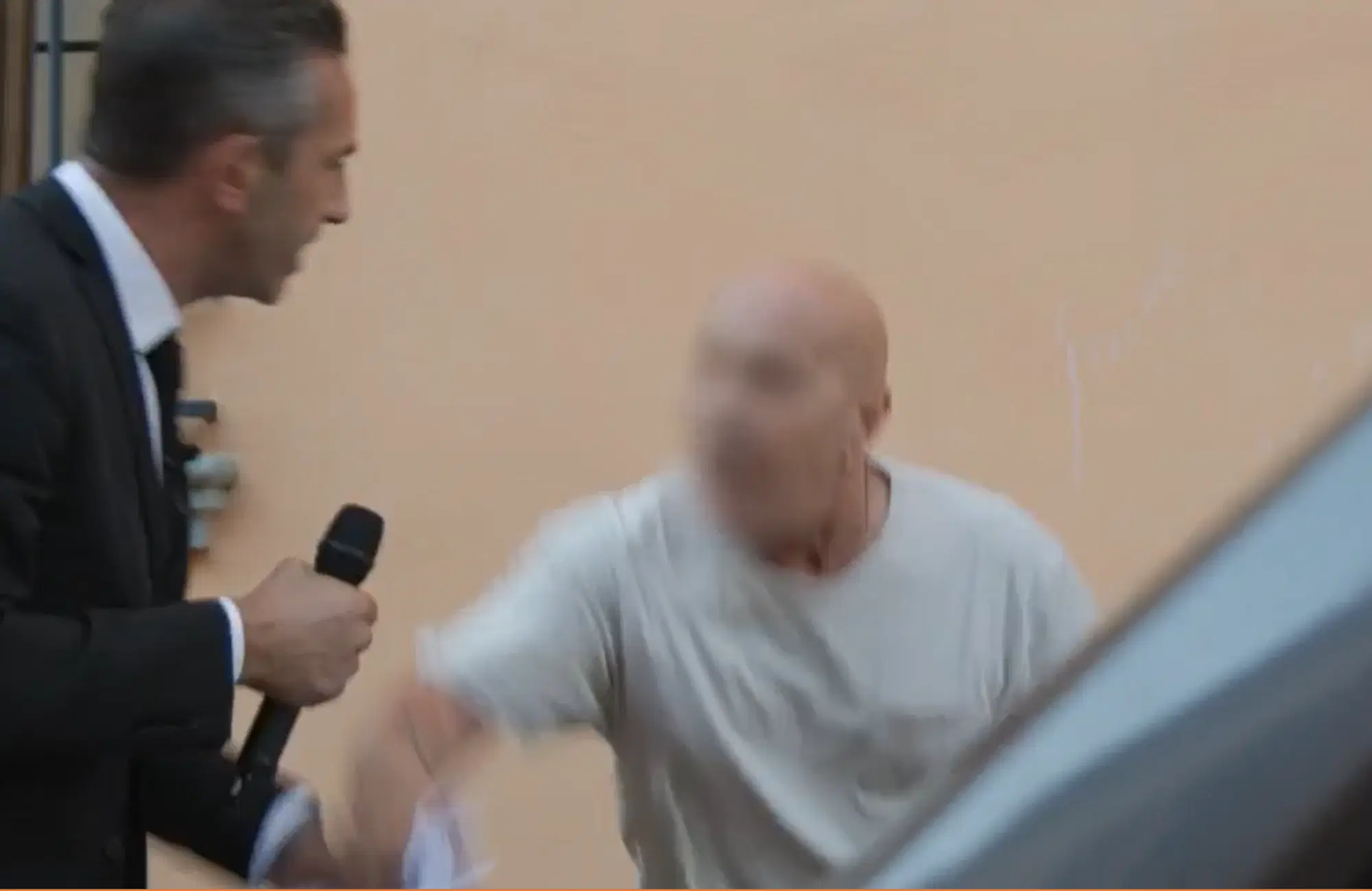 Il 65enne al centro del servizio de Le Iene, con il volto scurato, mentre tenta di strappare dei fogli dell'inviato