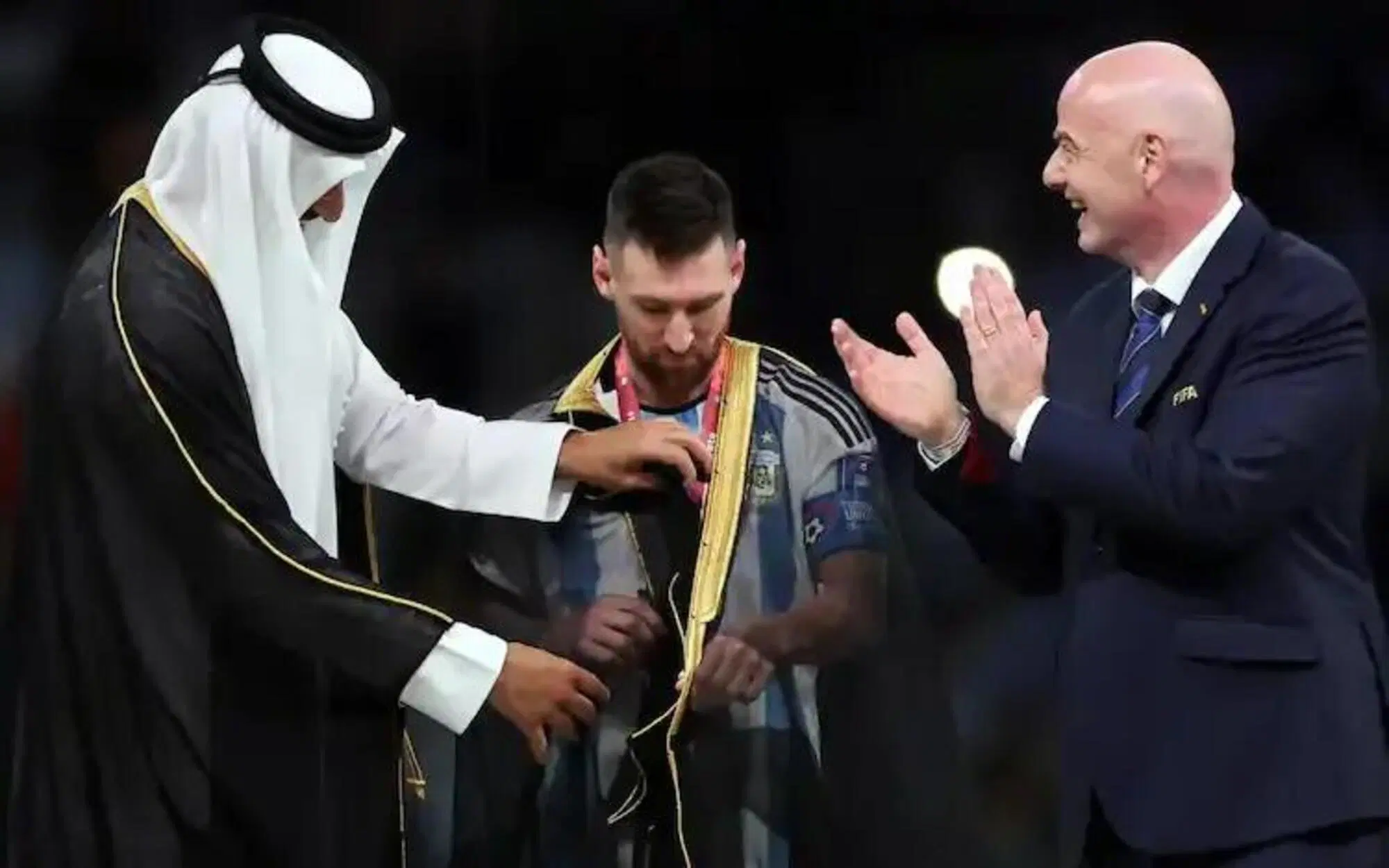 Messi, insieme all'Emiro Al-Thani e a Giorgio Infantino (Fifa), con il bisht, il mantello tradizionale simbolo di ricchezza e potere