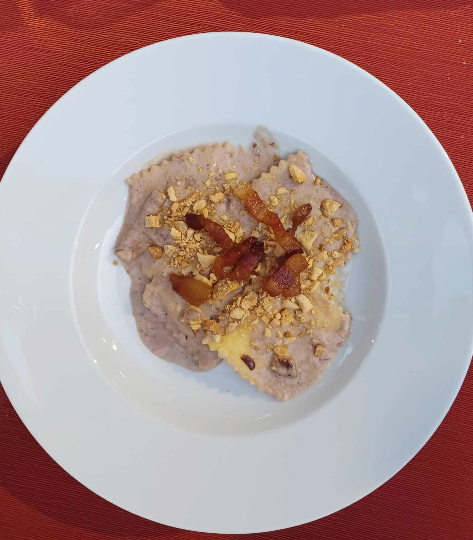 Ravioli di ricotta al radicchio con i formaggi, guanciale e mandorle tritate