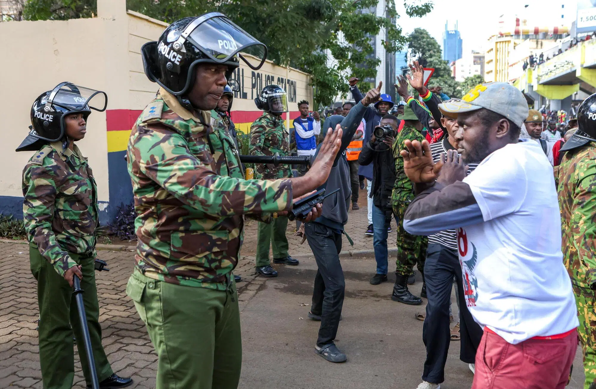 Proteste in Kenya: un manifestante fissa il poliziotto a braccia incrociate, come a dire: "Non ho paura e da qui non mi muovo"