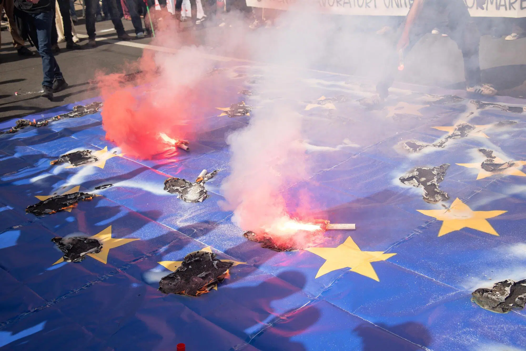 La bandiera dell'Unione europea bruciata durante una manifestazione