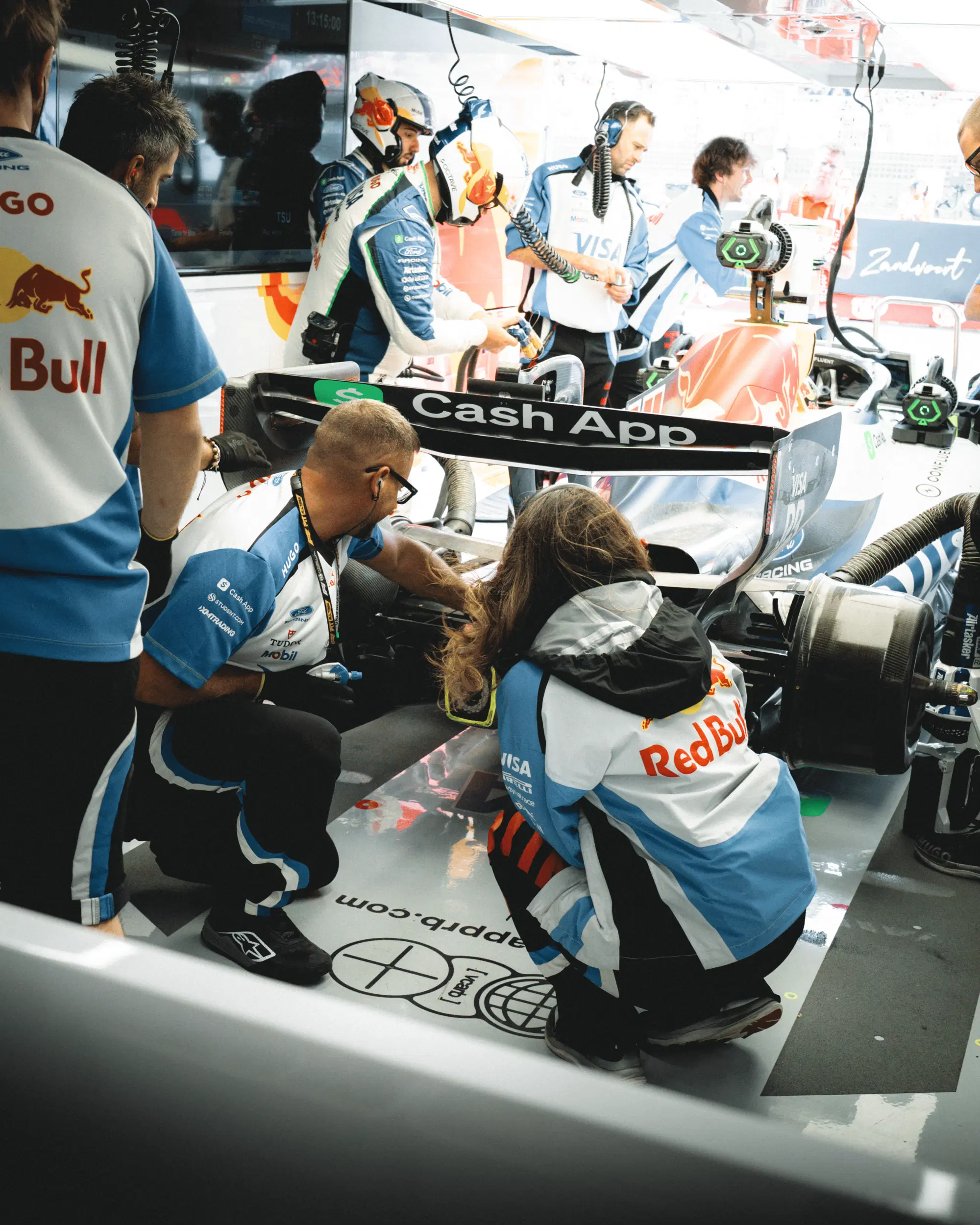 Due addetti della Racing Bulls controllano che il posteriore della VCARB-03 sia okay, 2026.